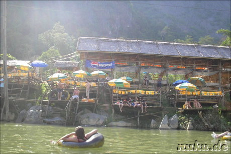 Touristen lassen sich im Reifen ueber den Fluss treiben, Vang Vieng