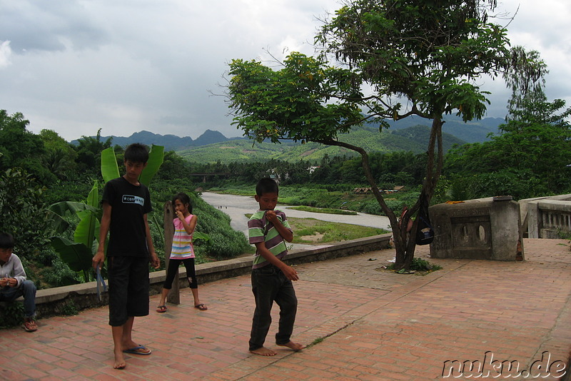 Laotische Kinder spielen am Nam Khan Fluss in Luang Prabang