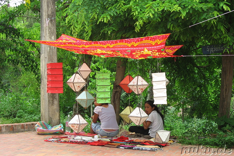 Laotische Kinder verkaufen Laternen am Strassenrand
