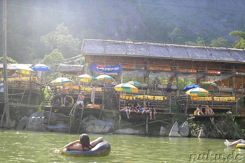 Touristen lassen sich im Reifen über den Fluss treiben, Vang Vieng