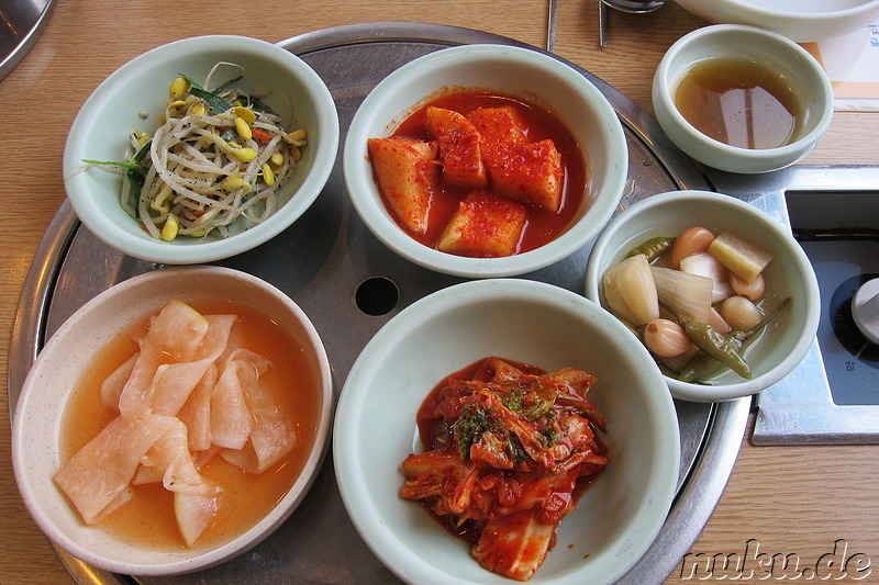 Verschiedene Beilagen, u.a. Kimchi aus Chinakohl und Rettich, eingelegtes Knoblauch